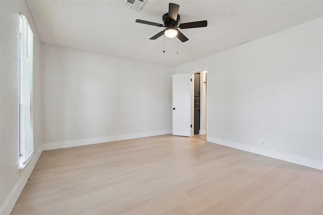 2322 Ripple Creek Ln, Edmond, OK 73012 - spare room with light wood-style flooring, a textured ceiling, and a ceiling fan