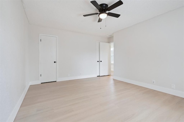 2322 Ripple Creek Ln, Edmond, OK 73012 - spare room with light wood finished floors, ceiling fan, and a textured ceiling