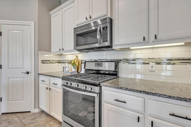 18608 Summer Grove Ave, Edmond, OK 73012 - kitchen featuring appliances with stainless steel finishes, dark stone countertops, white cabinetry, and decorative backsplash