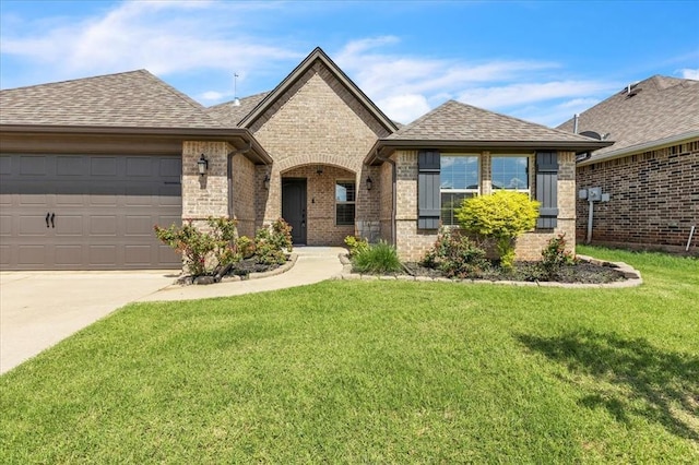 18608 Summer Grove Ave, Edmond, OK 73012 - view of front of home featuring a front yard, concrete driveway, brick siding, and a garage