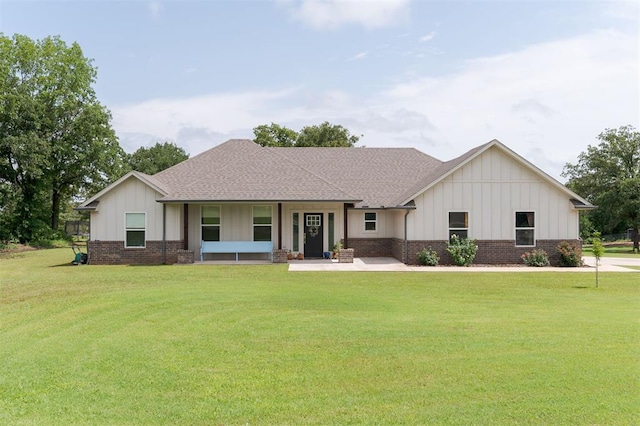 337030 E 1016th Rd, Meeker, OK 74855 - view of front of home with board and batten siding, brick siding, a front yard, and roof with shingles