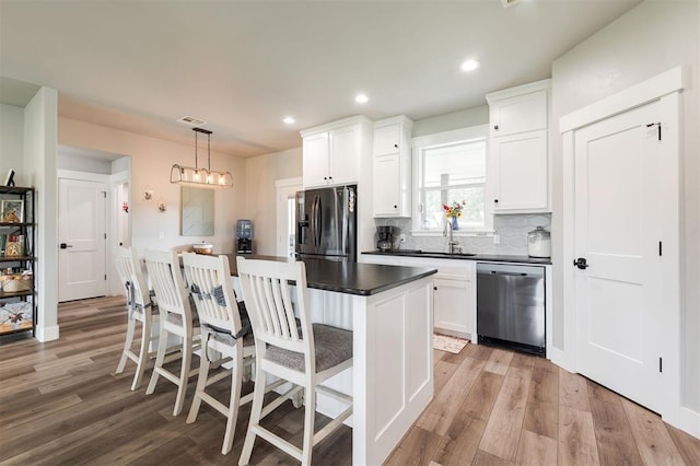 337030 E 1016th Rd, Meeker, OK 74855 - kitchen with stainless steel appliances, dark countertops, light wood-style flooring, white cabinets, and recessed lighting