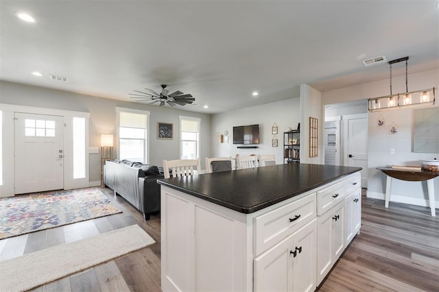 337030 E 1016th Rd, Meeker, OK 74855 - kitchen with dark countertops, wood finished floors, recessed lighting, white cabinetry, and open floor plan