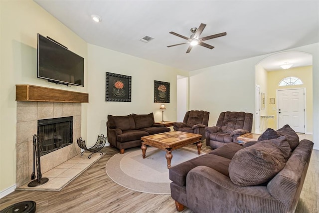 3751 Rock Dove Lndg, Edmond, OK 73034 - living area featuring arched walkways, wood finished floors, ceiling fan, and a tiled fireplace