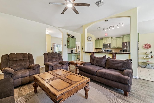3751 Rock Dove Lndg, Edmond, OK 73034 - living room featuring ceiling fan, arched walkways, light wood-type flooring, lofted ceiling, and track lighting