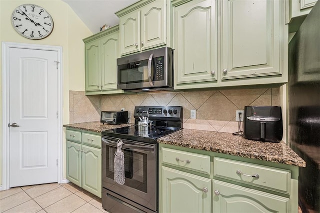 3751 Rock Dove Lndg, Edmond, OK 73034 - kitchen featuring stainless steel appliances, green cabinets, vaulted ceiling, decorative backsplash, and light tile patterned flooring