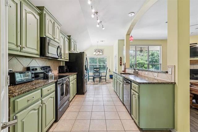3751 Rock Dove Lndg, Edmond, OK 73034 - kitchen featuring green cabinets, appliances with stainless steel finishes, decorative backsplash, lofted ceiling, and dark stone counters