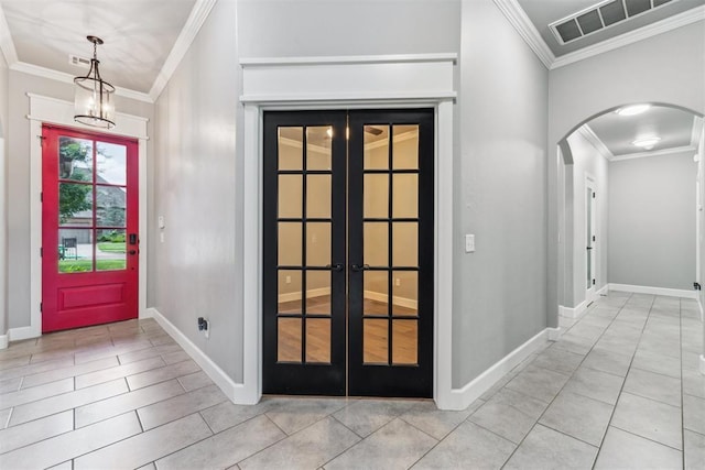 9041 NW 147th Ter, Yukon, OK 73099 - foyer entrance featuring arched walkways, ornamental molding, french doors, light tile patterned floors, and a chandelier