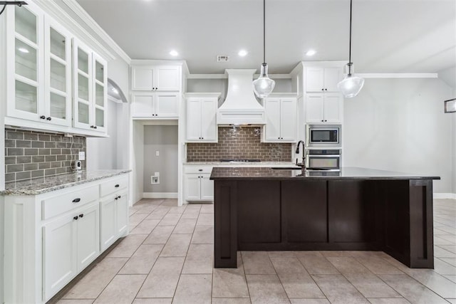 9041 NW 147th Ter, Yukon, OK 73099 - kitchen with custom range hood, appliances with stainless steel finishes, ornamental molding, backsplash, and white cabinets