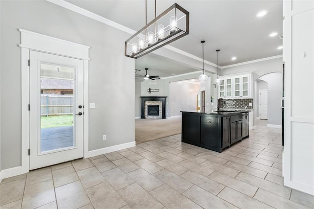 9041 NW 147th Ter, Yukon, OK 73099 - kitchen featuring dark countertops, crown molding, arched walkways, dark cabinets, and a ceiling fan