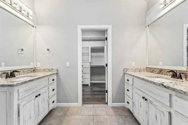 9041 NW 147th Ter, Yukon, OK 73099 - full bath featuring two vanities, a walk in closet, and tile patterned flooring