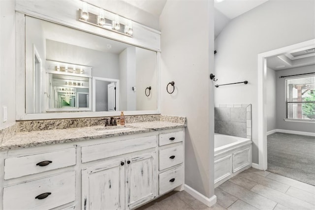 9041 NW 147th Ter, Yukon, OK 73099 - bathroom featuring a garden tub, vanity, and lofted ceiling
