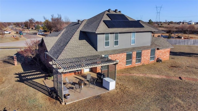 1045 Belmont Pl, Yukon, OK 73099 - rear view of house with solar panels, roof with shingles, and a fenced backyard