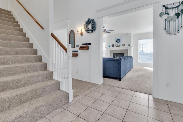 1045 Belmont Pl, Yukon, OK 73099 - staircase featuring carpet floors, ceiling fan, tile patterned floors, and a fireplace