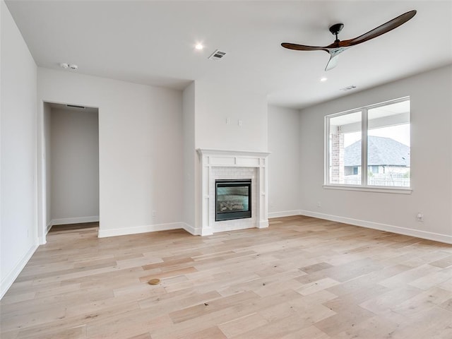 201 Pont Neuf Ct, Edmond, OK 73034 - unfurnished living room with ceiling fan, light wood-style flooring, a glass covered fireplace, and recessed lighting