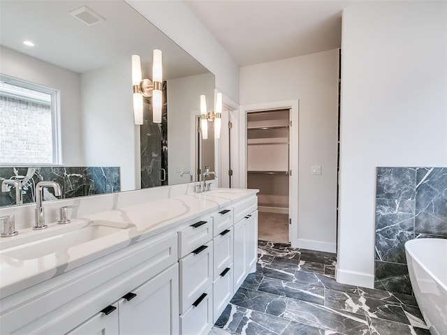 201 Pont Neuf Ct, Edmond, OK 73034 - full bath featuring a freestanding bath, double vanity, marble finish flooring, and a spacious closet