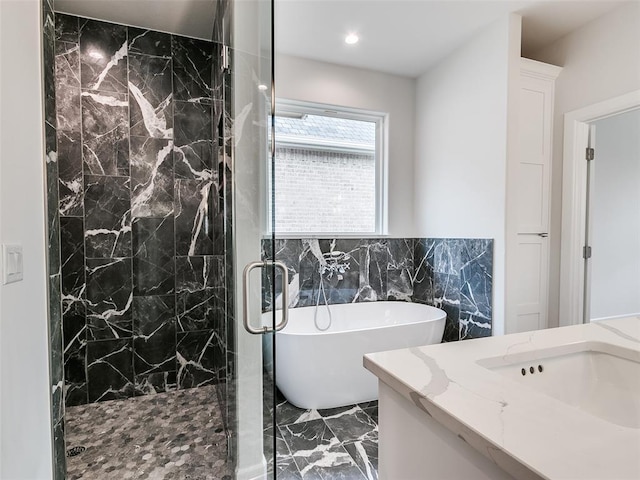201 Pont Neuf Ct, Edmond, OK 73034 - full bathroom featuring marble tiled floors, a freestanding tub, a marble finish shower, tile walls, and vanity