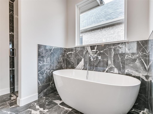 201 Pont Neuf Ct, Edmond, OK 73034 - full bath featuring marble tiled floors, tile walls, and a freestanding tub