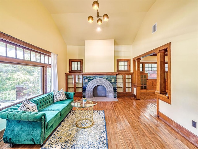 701 NW 21st St, Oklahoma City, OK 73103 - living area with high vaulted ceiling, wood finished floors, a chandelier, and a fireplace