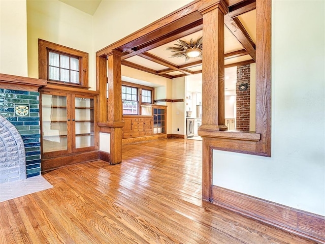 701 NW 21st St, Oklahoma City, OK 73103 - unfurnished living room with coffered ceiling, wood finished floors, decorative columns, beam ceiling, and crown molding