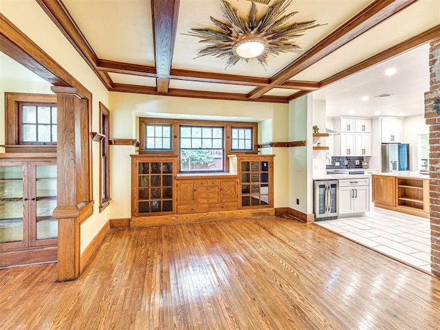 701 NW 21st St, Oklahoma City, OK 73103 - unfurnished living room featuring beverage cooler, light wood-style flooring, healthy amount of natural light, beam ceiling, and crown molding
