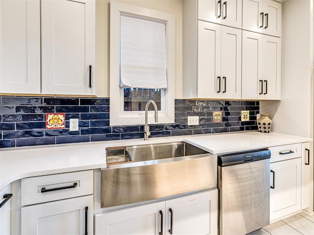 701 NW 21st St, Oklahoma City, OK 73103 - kitchen with stainless steel dishwasher, tasteful backsplash, light countertops, and white cabinets
