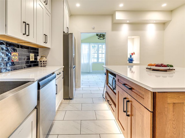 701 NW 21st St, Oklahoma City, OK 73103 - kitchen with stainless steel appliances, decorative backsplash, recessed lighting, light countertops, and white cabinetry
