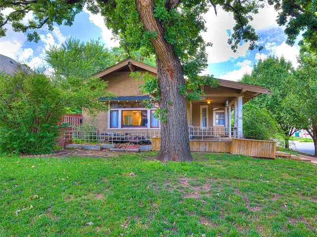 701 NW 21st St, Oklahoma City, OK 73103 - view of front of house with covered porch, a front lawn, and stucco siding