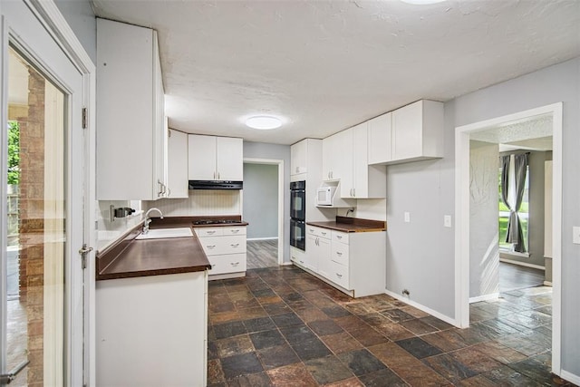11904 Somerville Dr, Yukon, OK 73099 - kitchen with dark countertops, black appliances, white cabinets, dark stone finish flooring, and a textured ceiling