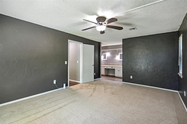 11904 Somerville Dr, Yukon, OK 73099 - unfurnished bedroom featuring carpet floors, ceiling fan, connected bathroom, and a textured ceiling
