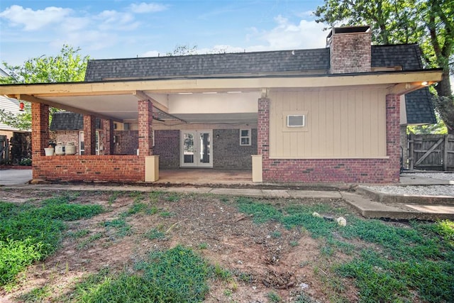 11904 Somerville Dr, Yukon, OK 73099 - back of house featuring brick siding, a shingled roof, a chimney, and french doors