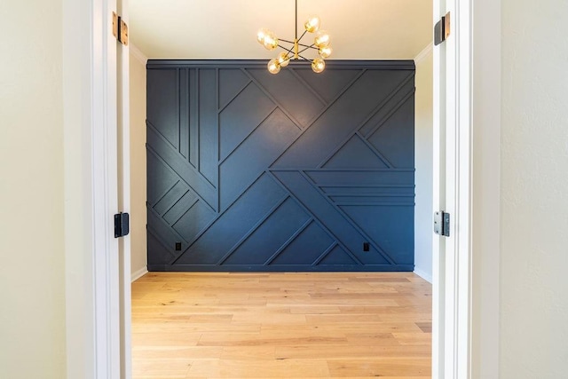 4334 White Ash Dr, Piedmont, OK 73078 - spare room featuring a chandelier, a decorative wall, and light wood-type flooring