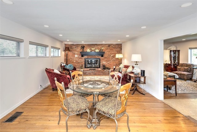 2299 Coretta Ave, Duncan, OK 73534 - dining room with a brick fireplace, light wood-style flooring, ornamental molding, and recessed lighting