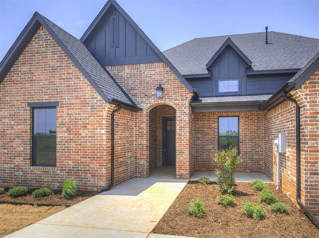 6881 Lake View Ct, Cashion, OK 73016 - view of front facade with board and batten siding, brick siding, and roof with shingles