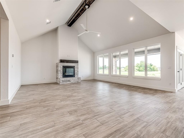 6881 Lake View Ct, Cashion, OK 73016 - unfurnished living room with beam ceiling, a ceiling fan, high vaulted ceiling, a stone fireplace, and light wood-style floors