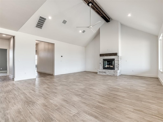 6881 Lake View Ct, Cashion, OK 73016 - unfurnished living room featuring ceiling fan, beam ceiling, a stone fireplace, light wood finished floors, and high vaulted ceiling