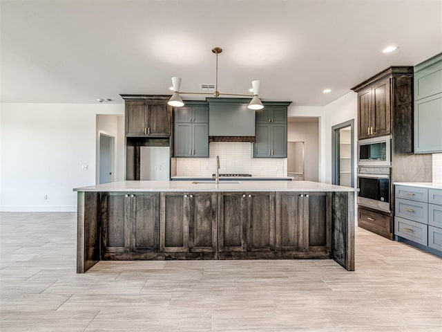 6881 Lake View Ct, Cashion, OK 73016 - kitchen with appliances with stainless steel finishes, light countertops, decorative backsplash, a large island with sink, and recessed lighting