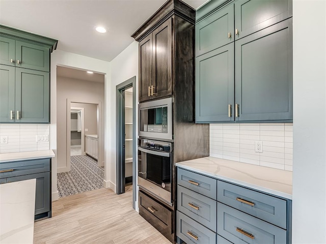 6881 Lake View Ct, Cashion, OK 73016 - kitchen featuring stainless steel appliances, light stone countertops, tasteful backsplash, light wood-type flooring, and recessed lighting