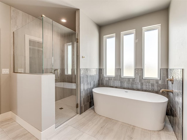 6881 Lake View Ct, Cashion, OK 73016 - full bathroom with tile walls, a freestanding tub, a shower stall, and a wainscoted wall