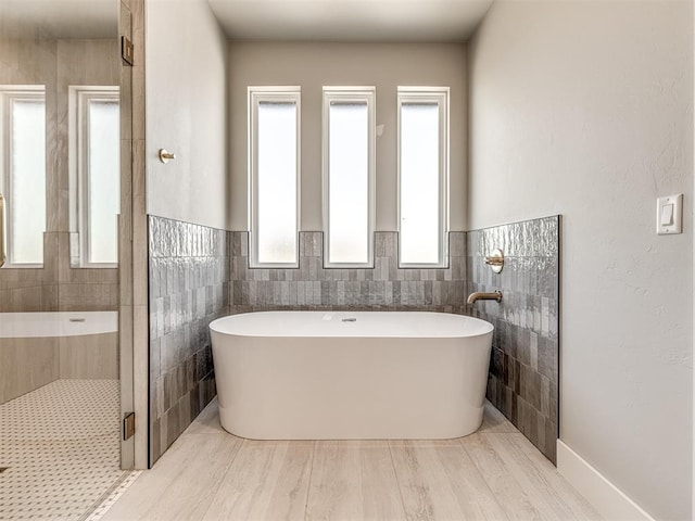 6881 Lake View Ct, Cashion, OK 73016 - bathroom with a soaking tub, tile walls, tiled shower, and a wainscoted wall