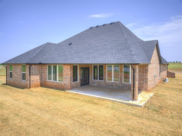 6881 Lake View Ct, Cashion, OK 73016 - rear view of property with brick siding, a shingled roof, a patio area, and a yard