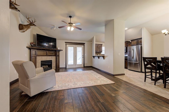 2305 Makaila Way, Yukon, OK 73099 - living room featuring vaulted ceiling, hardwood / wood-style floors, a tiled fireplace, and ceiling fan