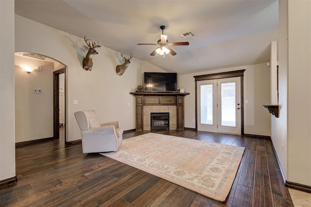 2305 Makaila Way, Yukon, OK 73099 - living area with a ceiling fan, hardwood / wood-style flooring, a tiled fireplace, vaulted ceiling, and arched walkways