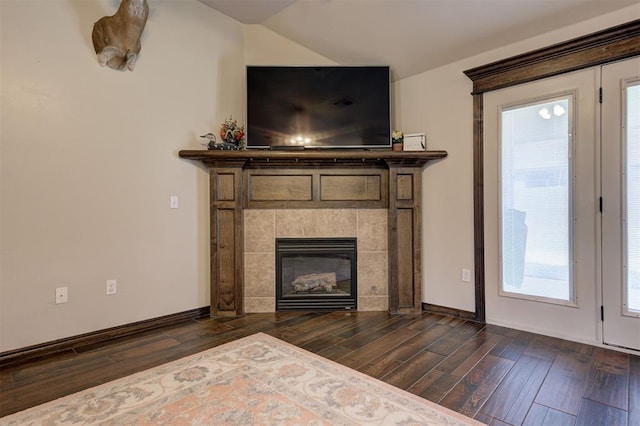 2305 Makaila Way, Yukon, OK 73099 - unfurnished living room featuring dark wood-style flooring, a tiled fireplace, plenty of natural light, and lofted ceiling