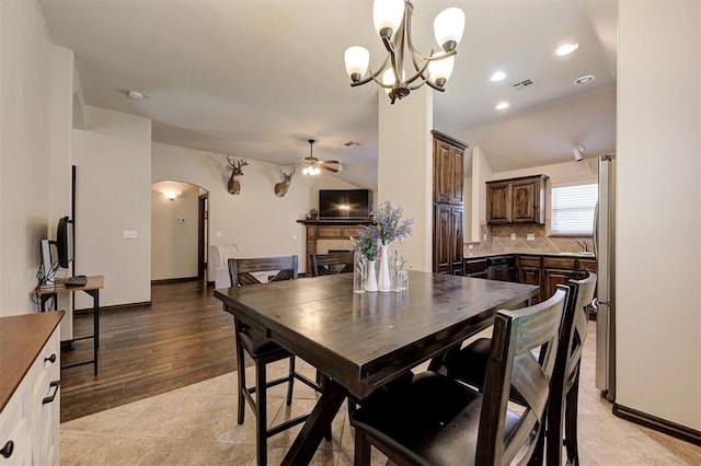 2305 Makaila Way, Yukon, OK 73099 - dining area featuring arched walkways, a fireplace, ceiling fan, a chandelier, and recessed lighting