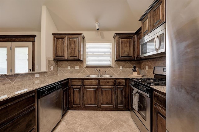 2305 Makaila Way, Yukon, OK 73099 - kitchen with stainless steel appliances, tasteful backsplash, dark brown cabinetry, light stone counters, and light tile patterned floors