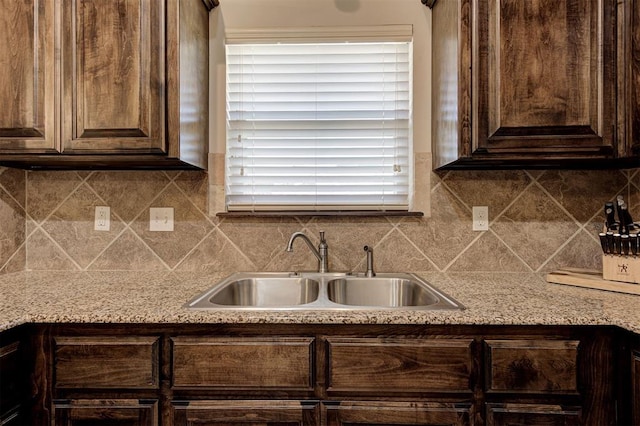 2305 Makaila Way, Yukon, OK 73099 - kitchen featuring dark brown cabinets, decorative backsplash, and light stone countertops