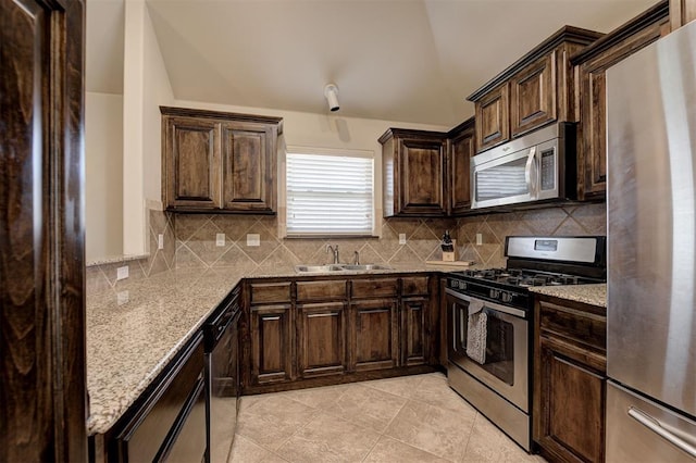 2305 Makaila Way, Yukon, OK 73099 - kitchen with stainless steel appliances, tasteful backsplash, vaulted ceiling, and light stone countertops