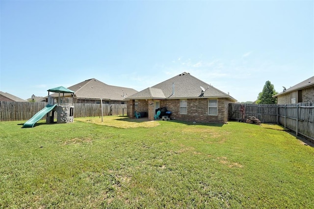 2305 Makaila Way, Yukon, OK 73099 - back of property with a playground, a fenced backyard, and brick siding