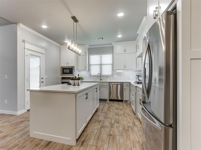 1391 Hickory Trl, Piedmont, OK 73078 - kitchen featuring stainless steel appliances, crown molding, light countertops, decorative backsplash, and light wood-style floors